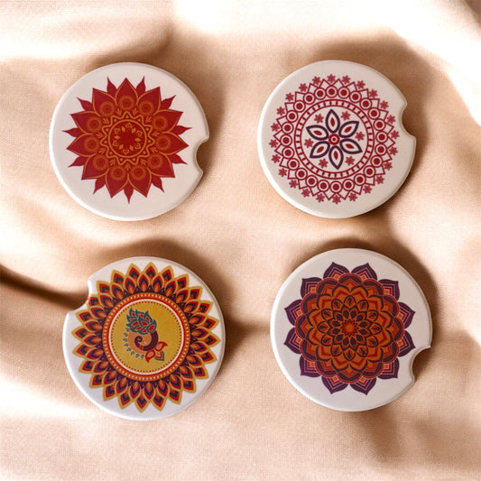 Four decorative coasters with mandala designs on a beige fabric background